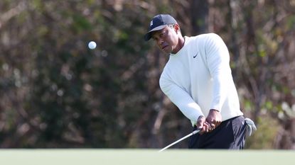 Tiger Woods hits a chip shot around the green