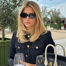 A woman sitting in a cafe in Paris with a bouncy blow-dry