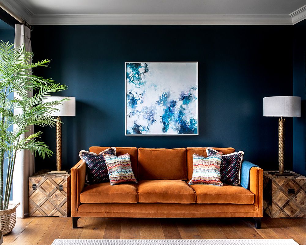 salon pomysły na malowanie niebieski pokój z pomarańczową sofą
