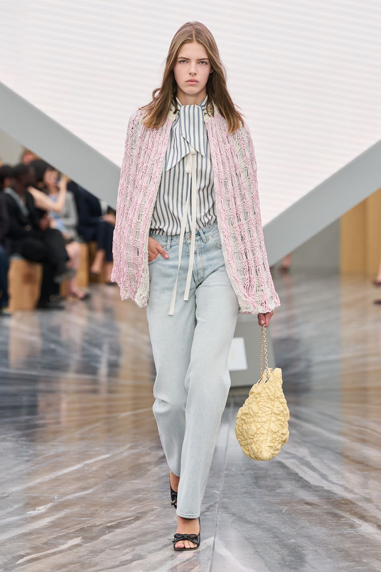 a woman wearing light wash cigarette jeans, a striped shirt, and pink cape on Dior's Spring 2026 runway
