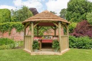 Thatched roof gazebo in rustic looking backyard