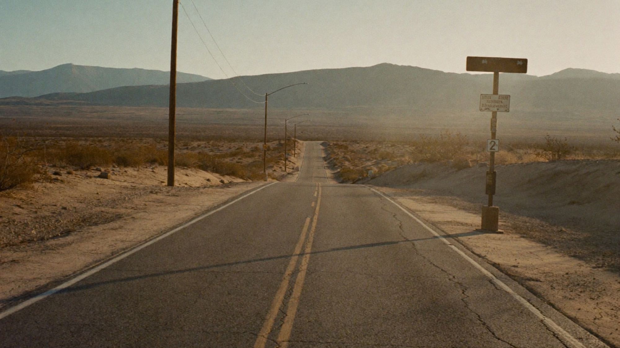 Route 66 - Empty desert highway stretches toward distant mountains unde - TVS.jpg