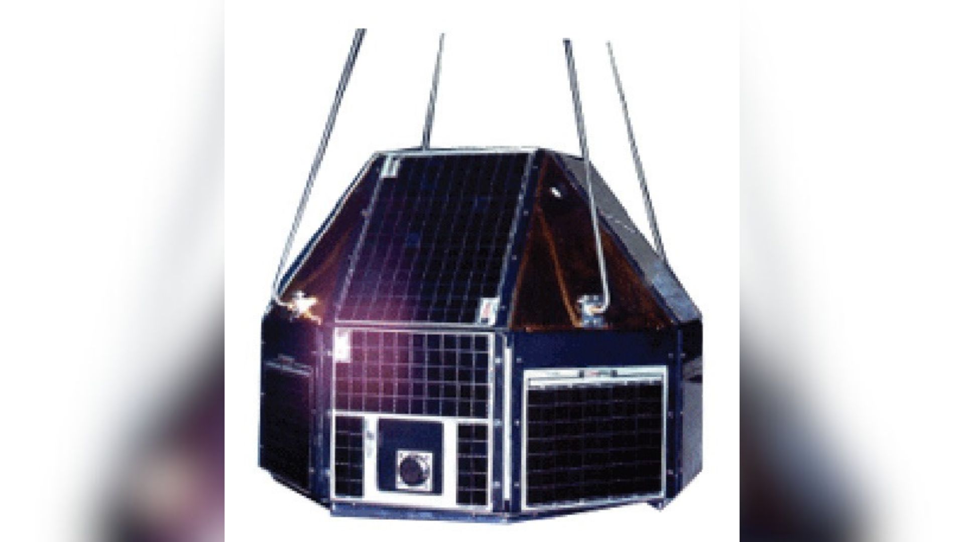 A metal polygonal satellite with solar panels on all sides is raised by four cables