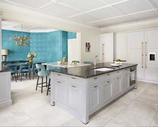 Grey dining room ideas by Martin Moore with kitchen island table and adjacent teal dining area