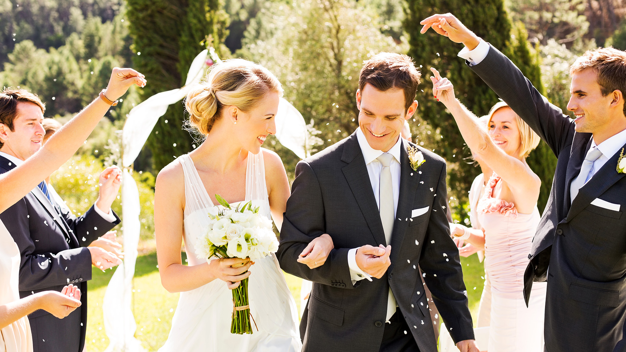 Couple, just married, being sprinkled with confetti