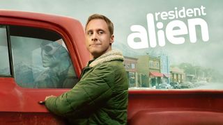 Harry står vid sin röda truck i Netflix-serien Resident Alien.