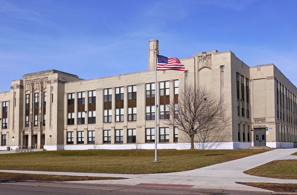 U.S. high school building with American flag.