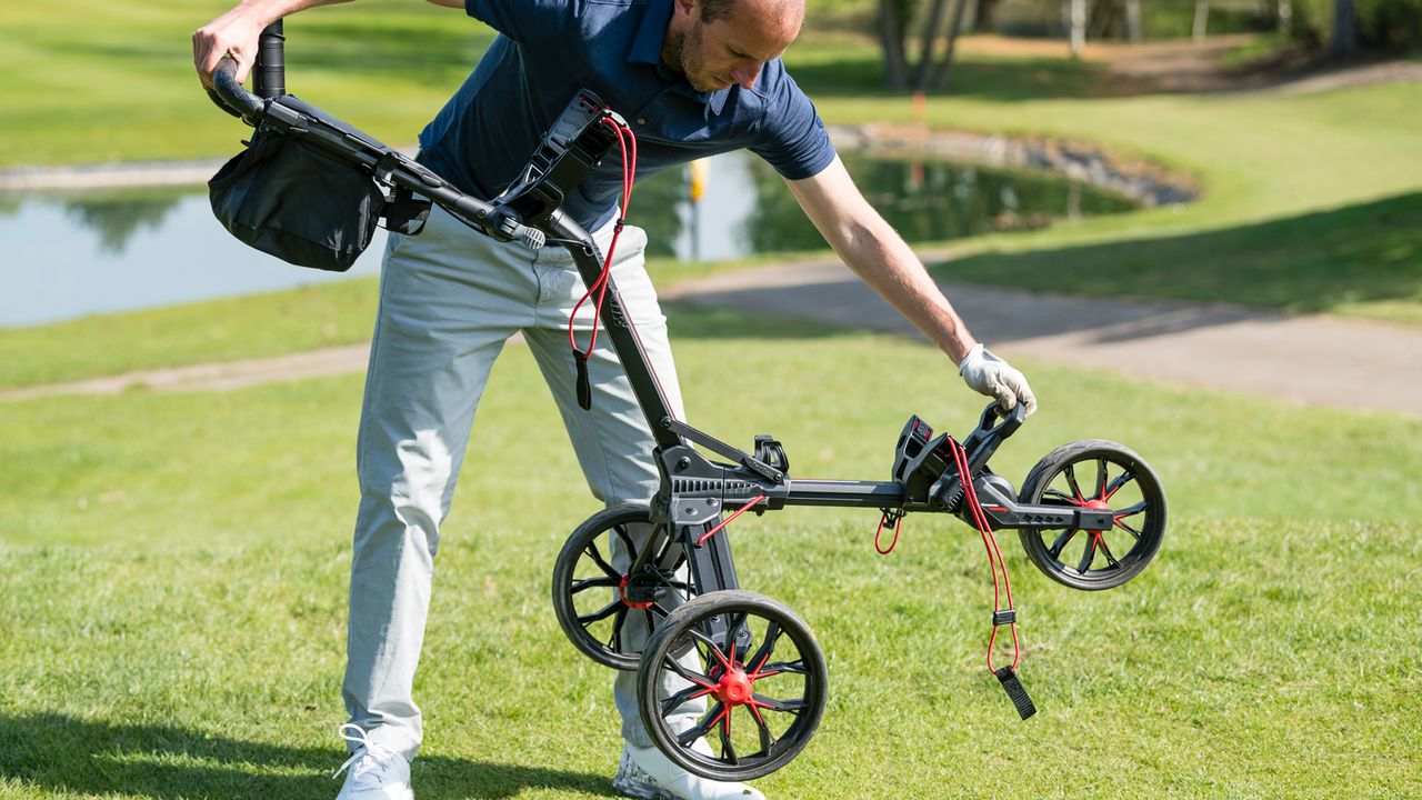 A golfer sets up the Bag Boy Nitron Push Cart