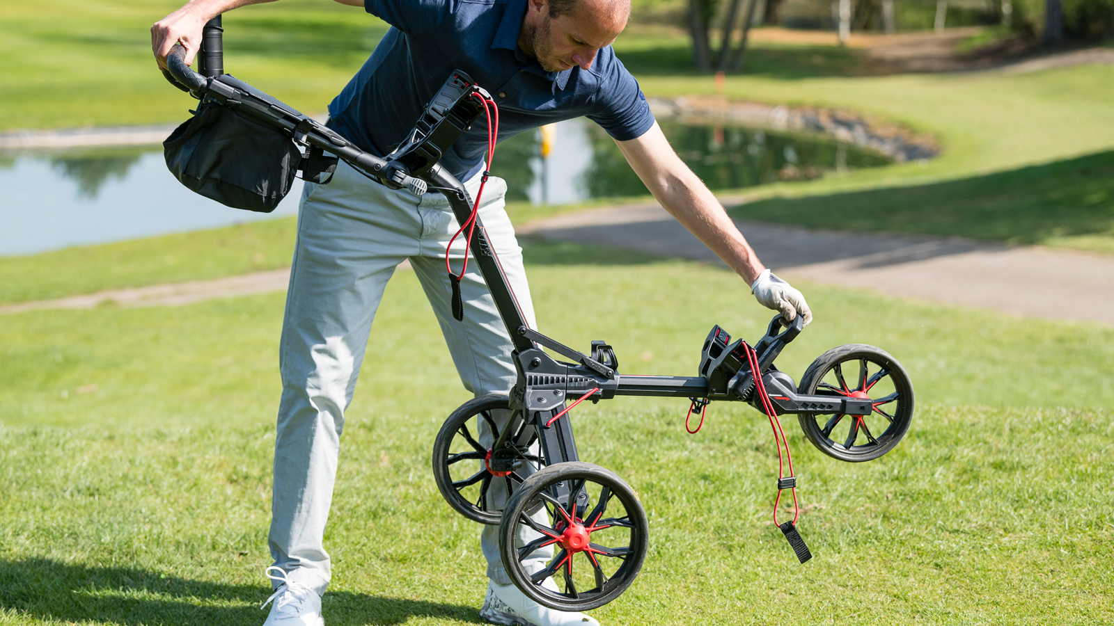 A golfer sets up the Bag Boy Nitron Push Cart