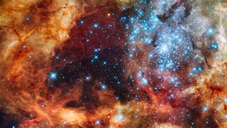 a dense region of stars in deep space surrounded by colorful clouds of gas
