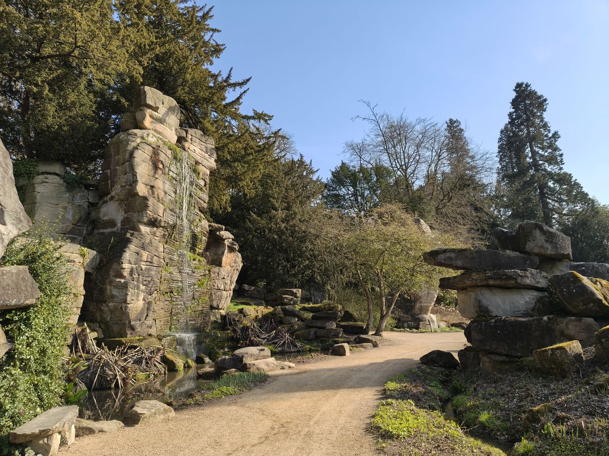 Large boulder next to a path and trees