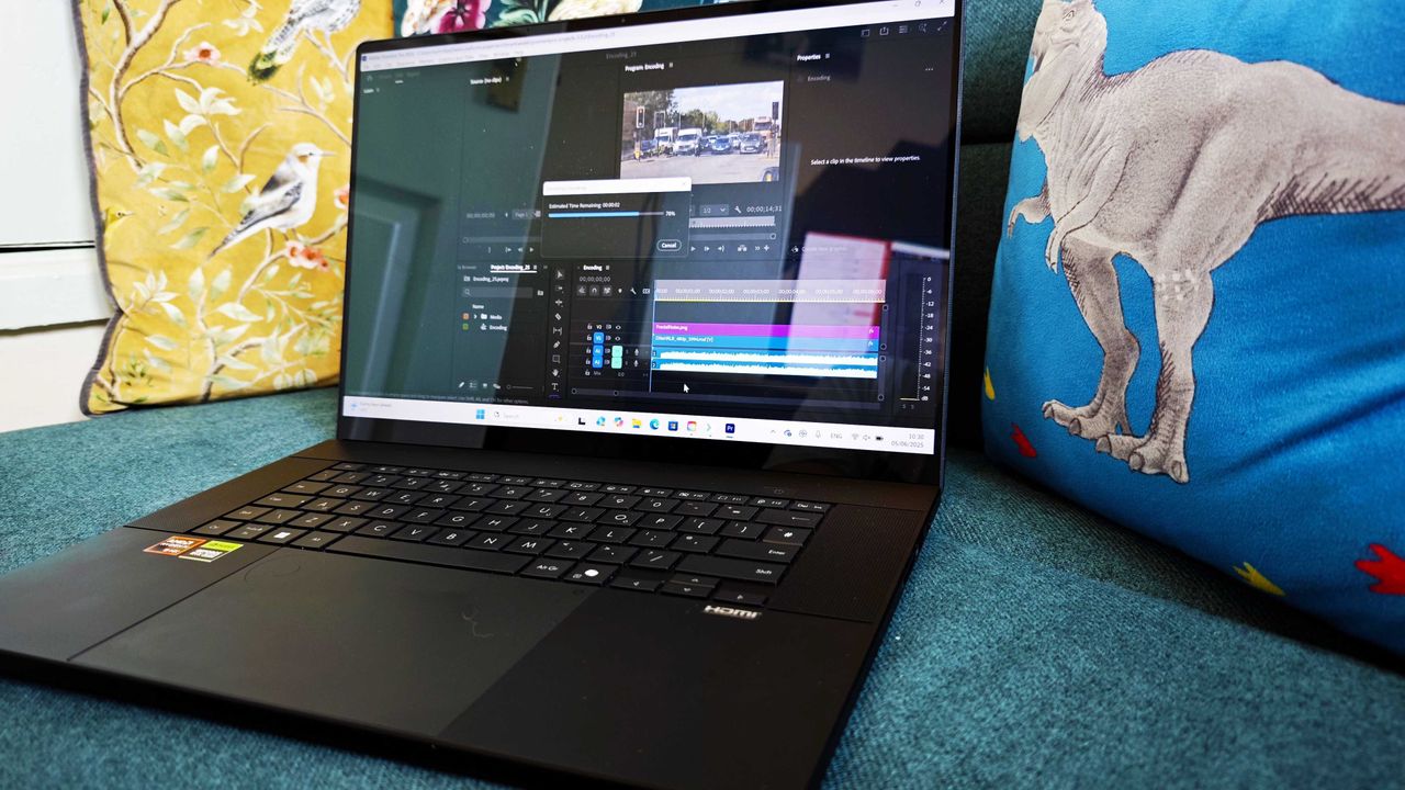 A black ASUS ProArt P16 laptop on a green sofa
