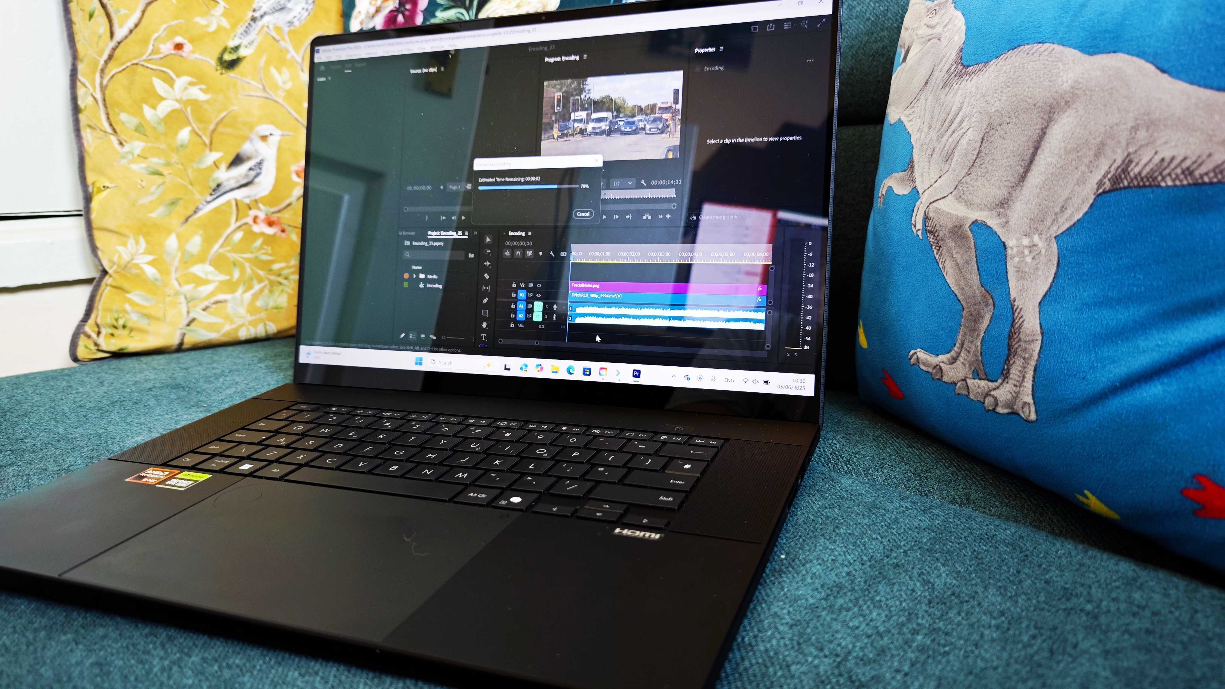 A black ASUS ProArt P16 laptop on a green sofa
