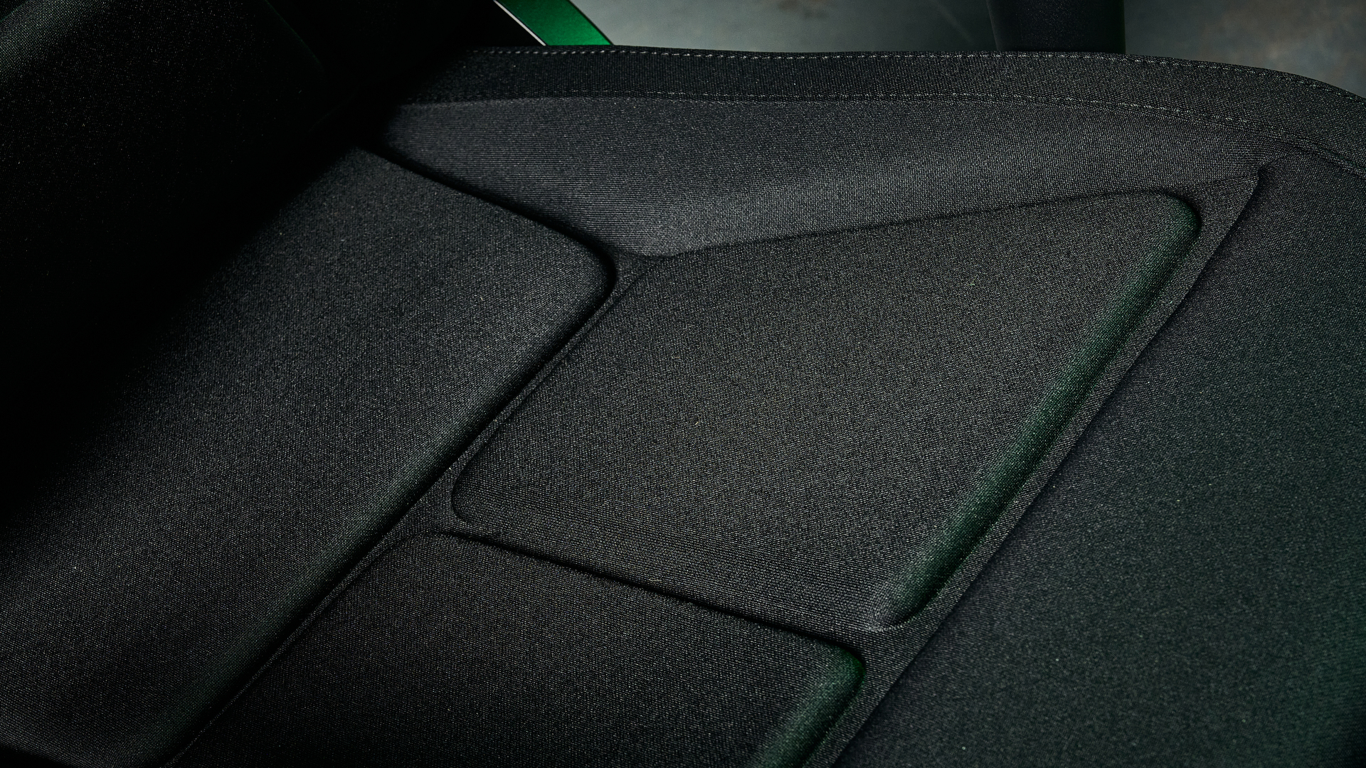 The Razer Soma Chroma chair seat base, illuminated with a green glow