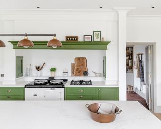 green kitchen white aga copper accents copper lighting painted cabinetry