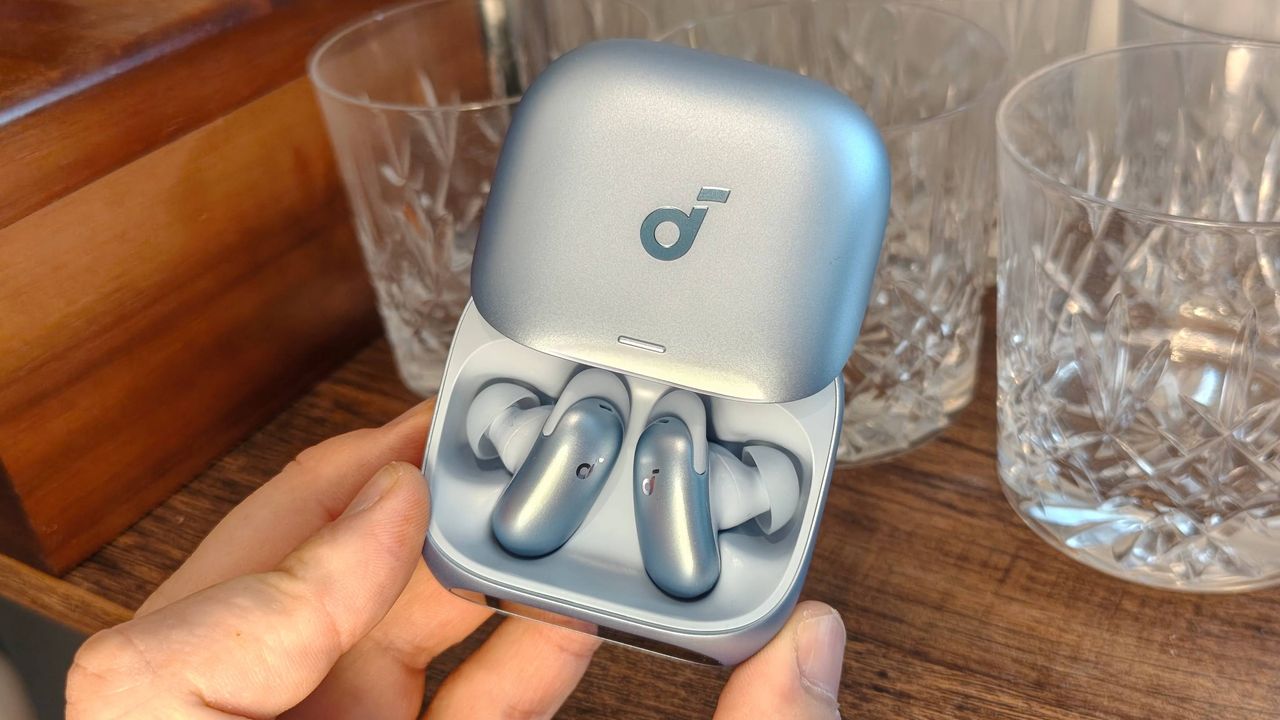 The Anker Soundcore Liberty 5 Pro on a shelf, next to some glasses.