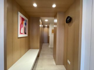 Third Avenue by Studio 397 Architecture features a long wood walled corridor with a painting on the left.