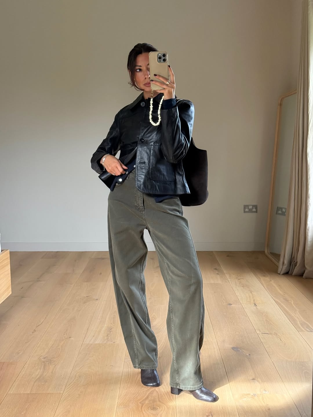 Woman wearing collared leather jacket trend fall 2025.