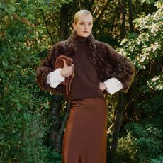 model wearing me+em fur coat, brown jumper and satin caramel skirt