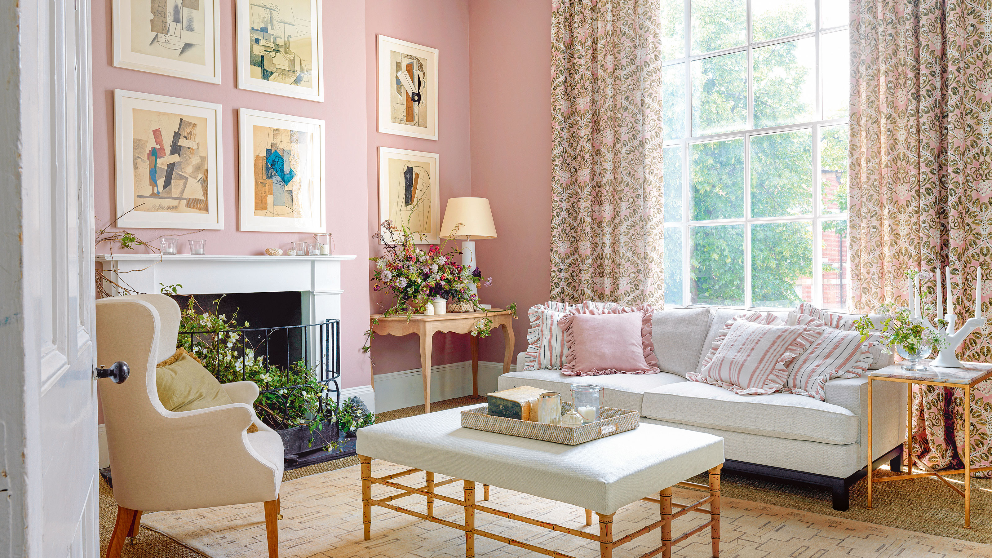 Pink living room with white sofa and ottoman and floral curtains 