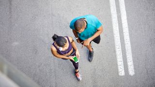a photo of two runners looking at a phone screen