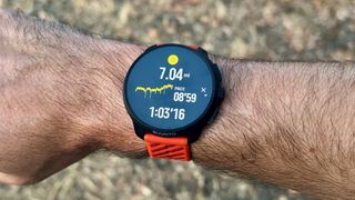 The Suunto Race 2 on the author's wrist showing a post-run summary with mileage, pace, and duration.
