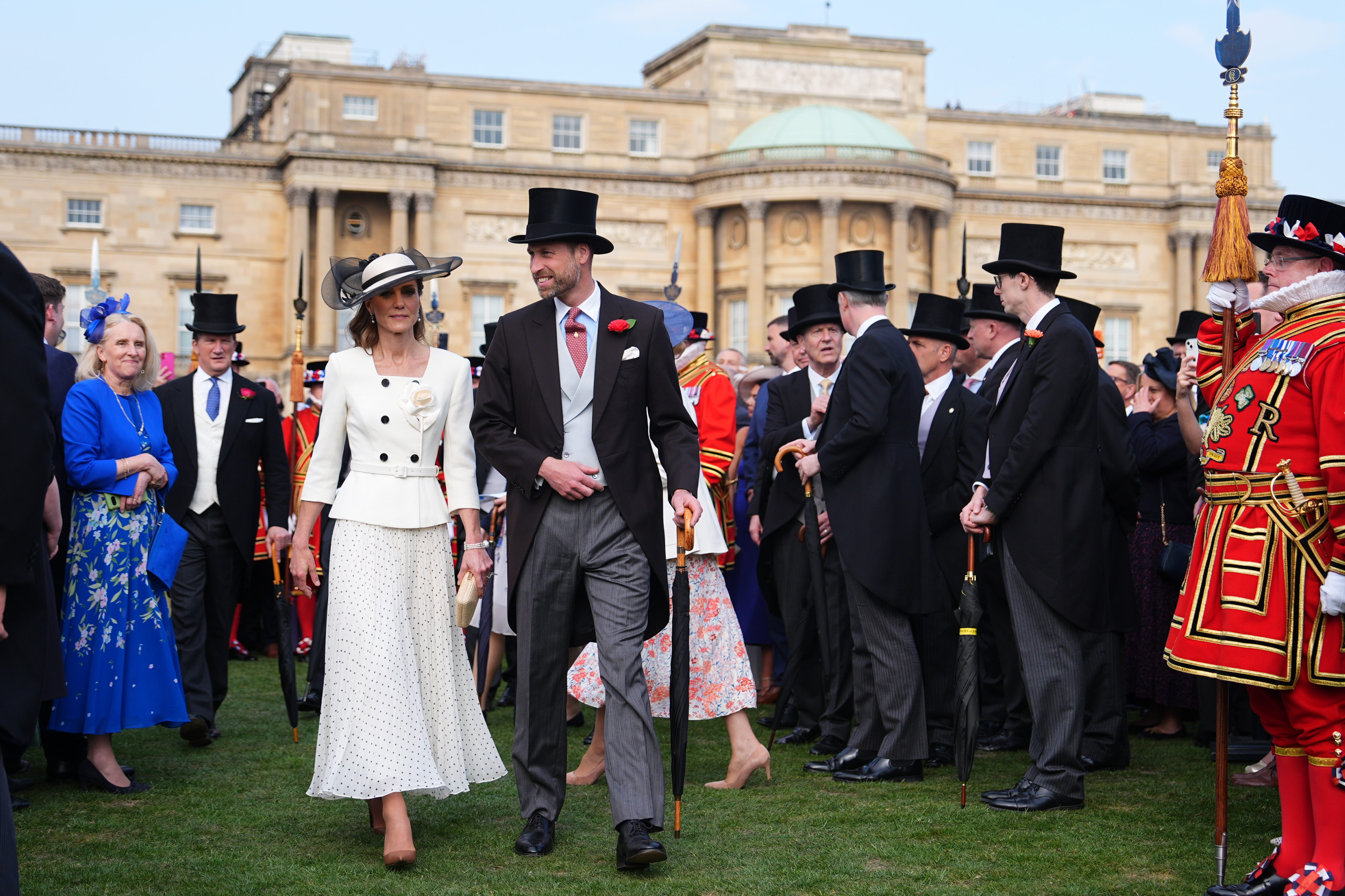 Prince William and Princess Kate walking through guests at a Buckingham Palace garden party