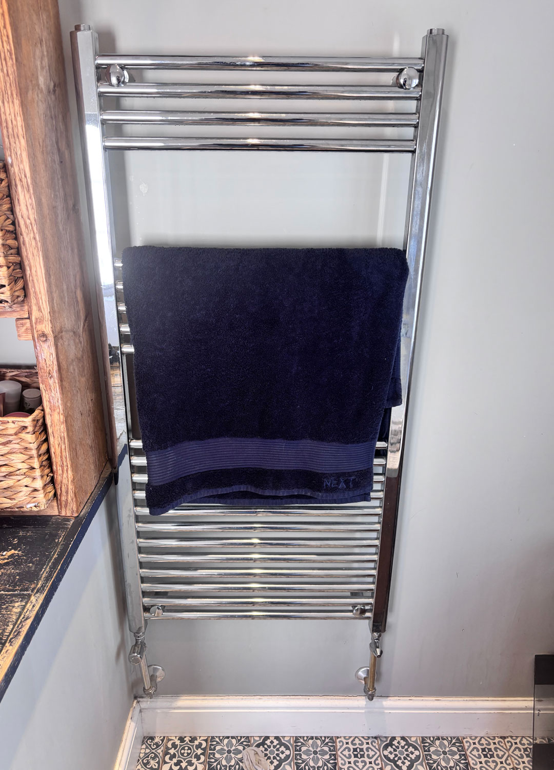 chrome heated towel rail with navy towel