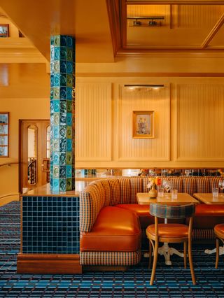 Blue-tilled column and retro dining seating at Public House Paris