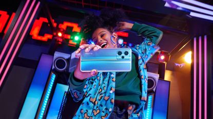 Realme 9 Pro review: woman dancing and holding a blue phone