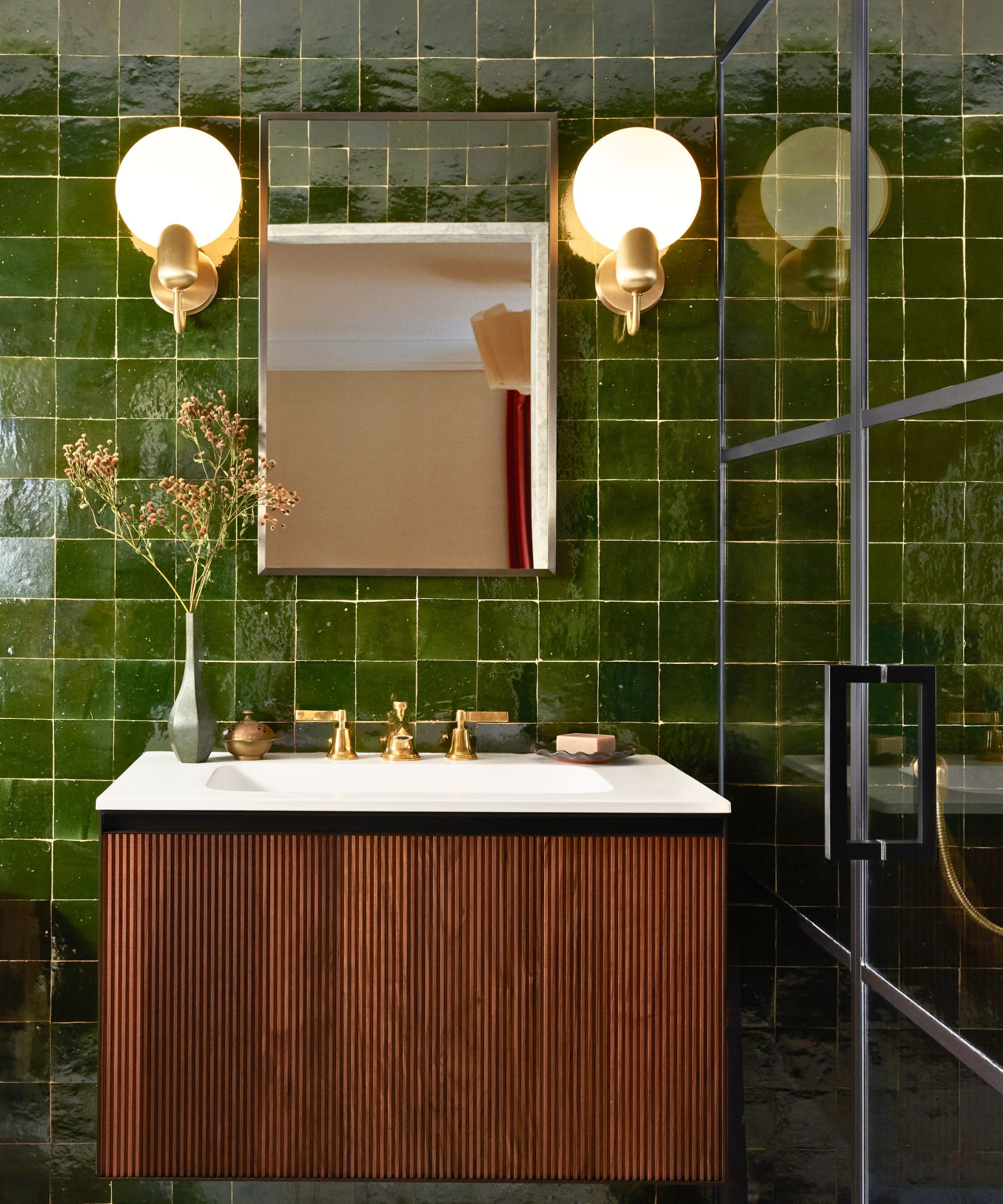 bathroom with shiny green square tiles and a reeded cabinet