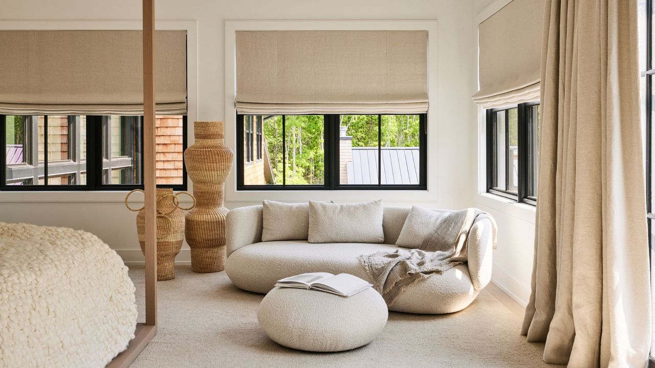 A spacious bedroom with a lounging couch and rattan décor