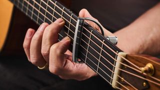 Close up of a capo on an acoustic guitar