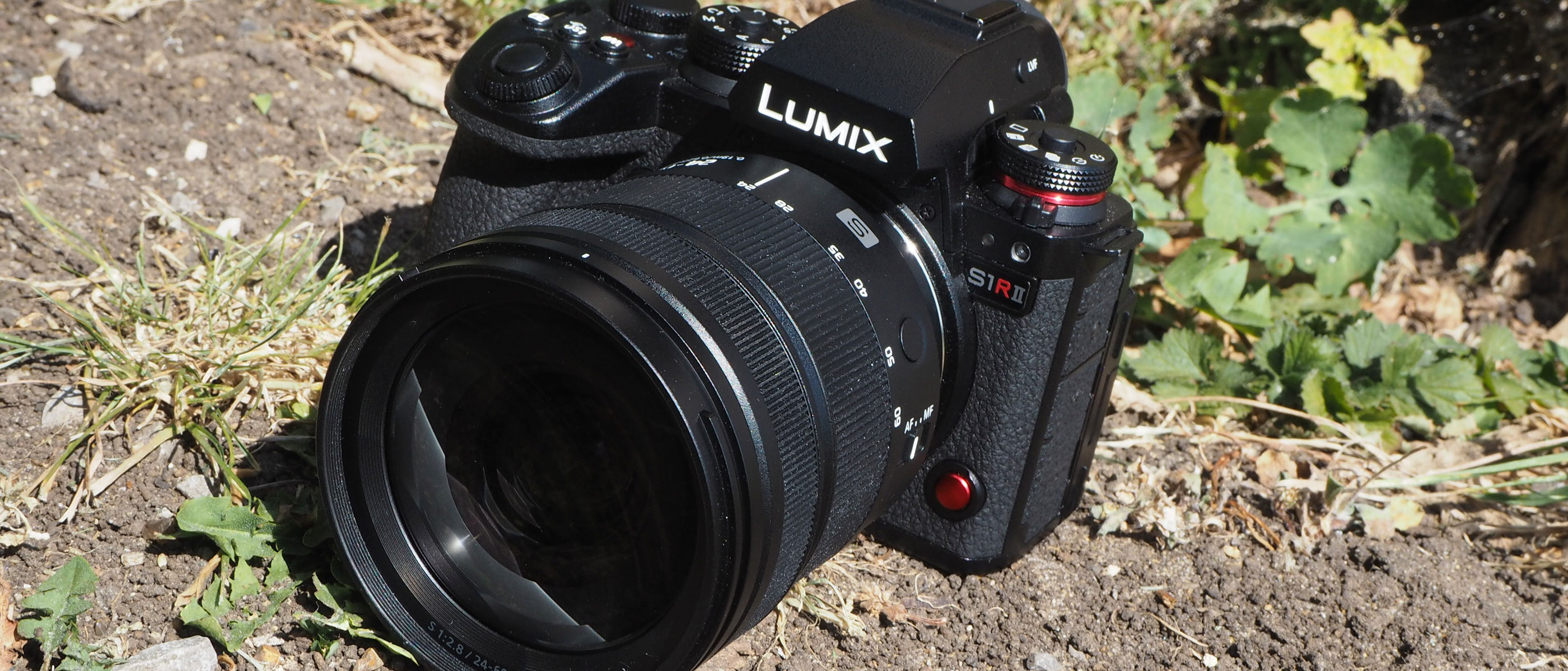 The Panasonic Lumix S1R II on the ground with foliage background.