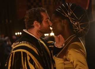 A tender moment between King Henry VIII (Mark Stanley) and Anne Boleyn (Jodie Turner-Smith) as he moves in to kiss her in a candelit room
