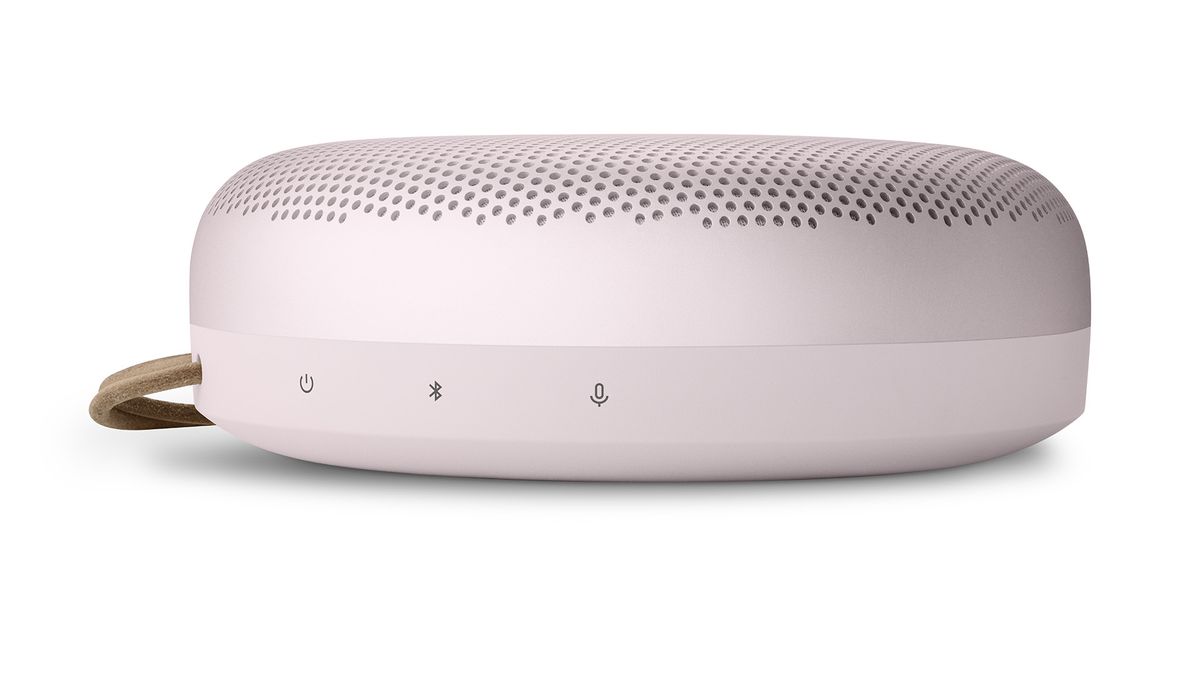 The side of a pink Bang &amp; Olufsen Beosound A1 (2nd Gen) showing some of the controls. The strap is just visible on the left side. The background is white.