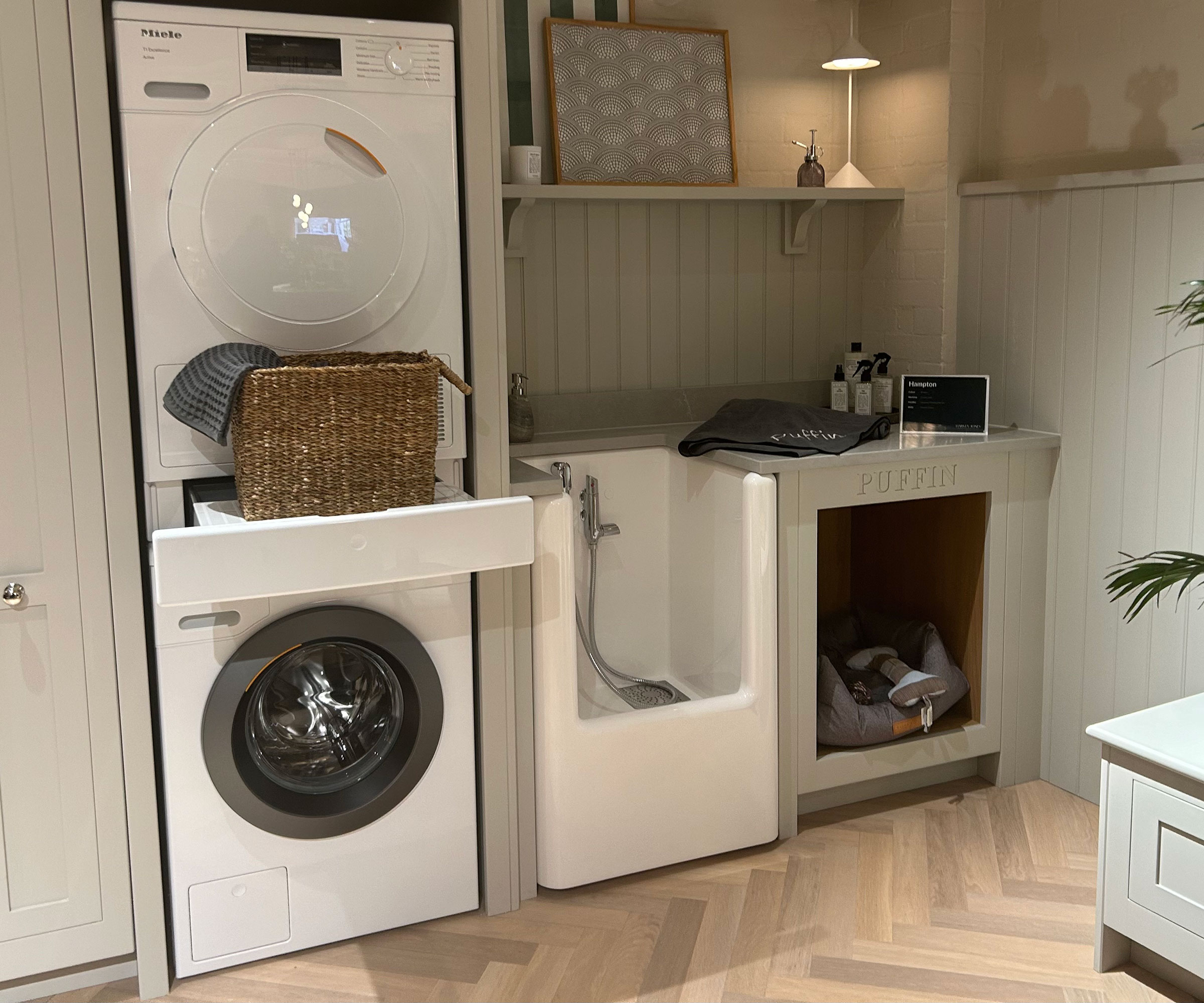 utility room with dog shower and built-in dog bed and stacked washing machine and dryer