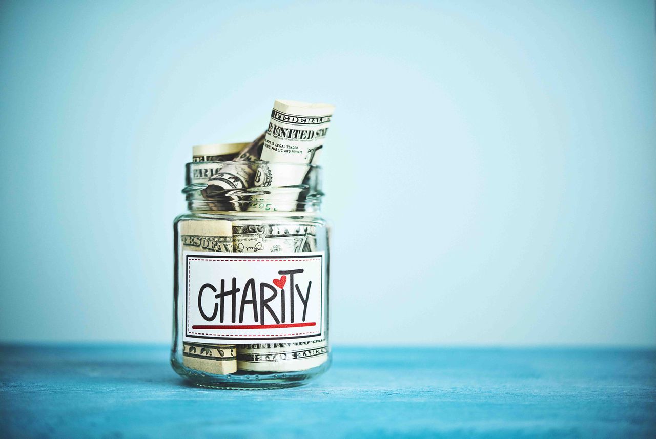 jar with paper money inside labeled charity