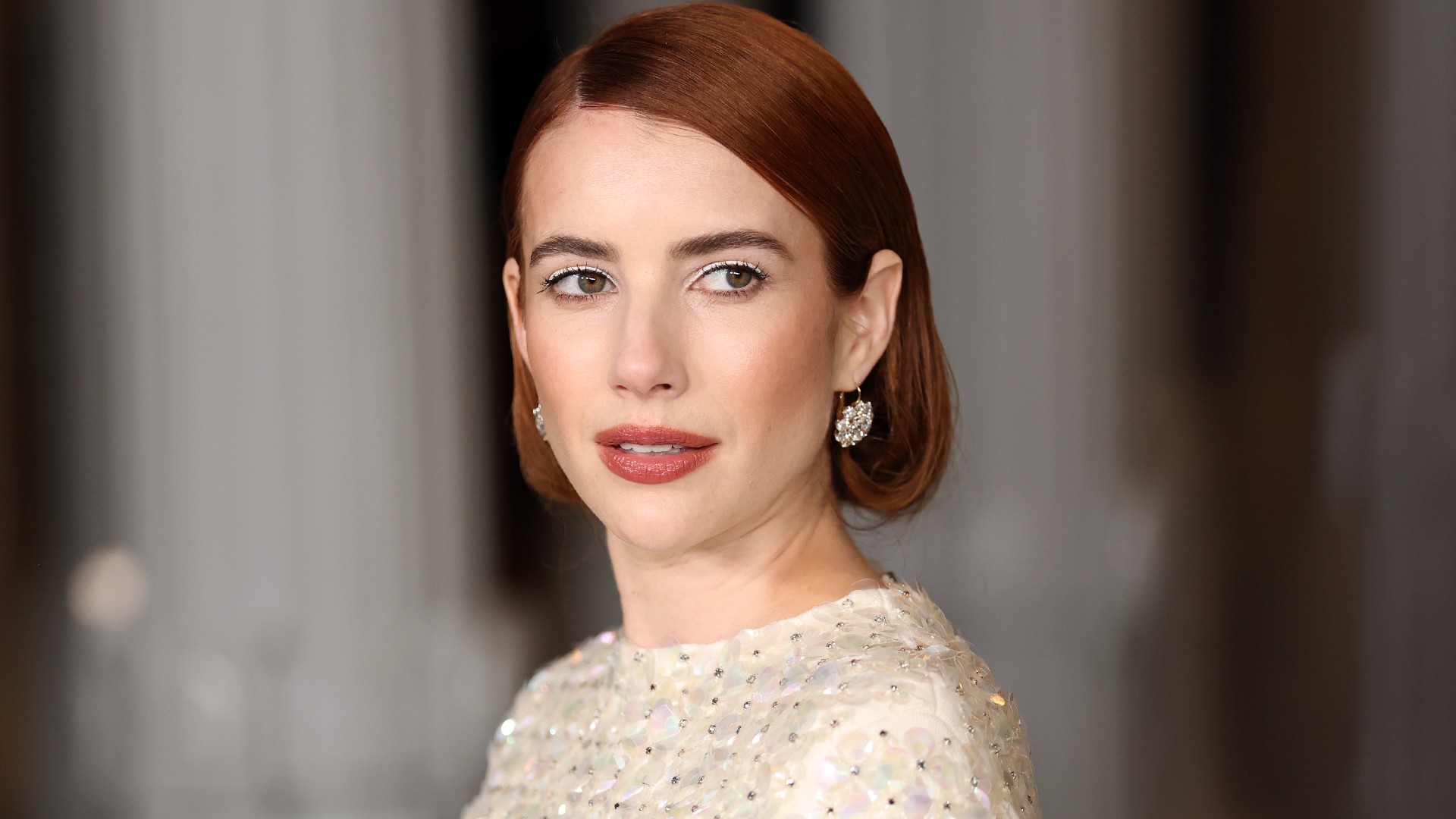 a white woman with red hair poses for a red carpet photo