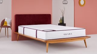 Awara mattress shown in an orange bedroom and placed on a wooden bed frame