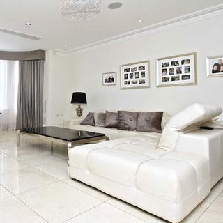 living room with white tiled flooring and sofaset with cushions