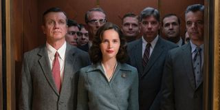 Ruth Bader Ginsburg (Felicity Jones) smiles while standing in an elevator full of men in 'On The Basis of Sex'