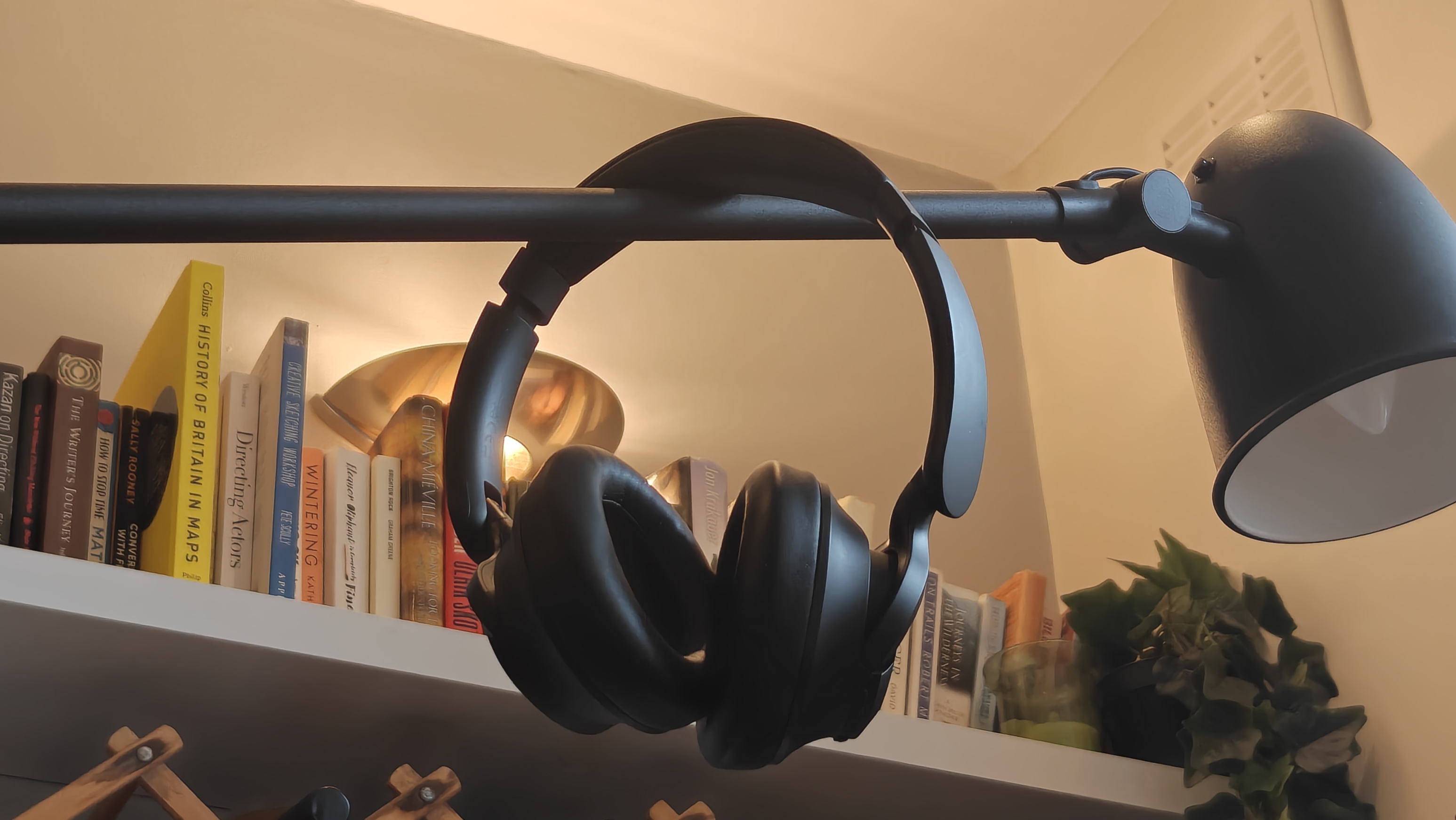 OneOdio Focus A1 Pro عبارة عن مصباح به رف كتب في الخلفية.