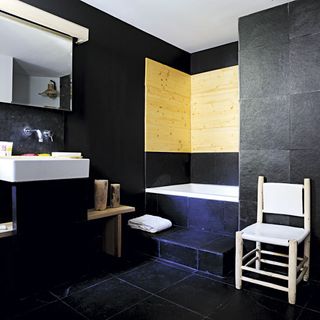 bathroom with white chair and black tiles