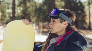 A snowboarder with her goggles pulled up over her head