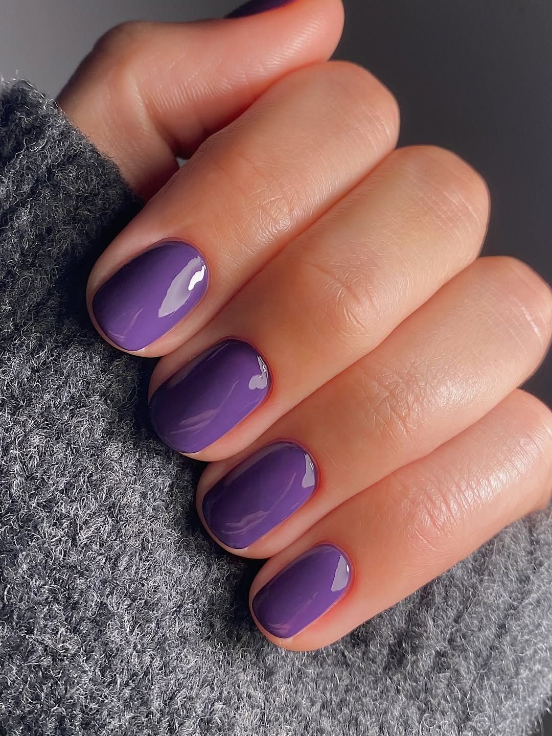 A close-up of a bold purple manicure