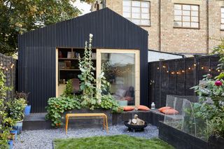 small garden room with black cladding and garden space