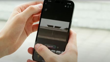 A person holding a smartphone with the Lumix Labs Magic LUTs on the screen
