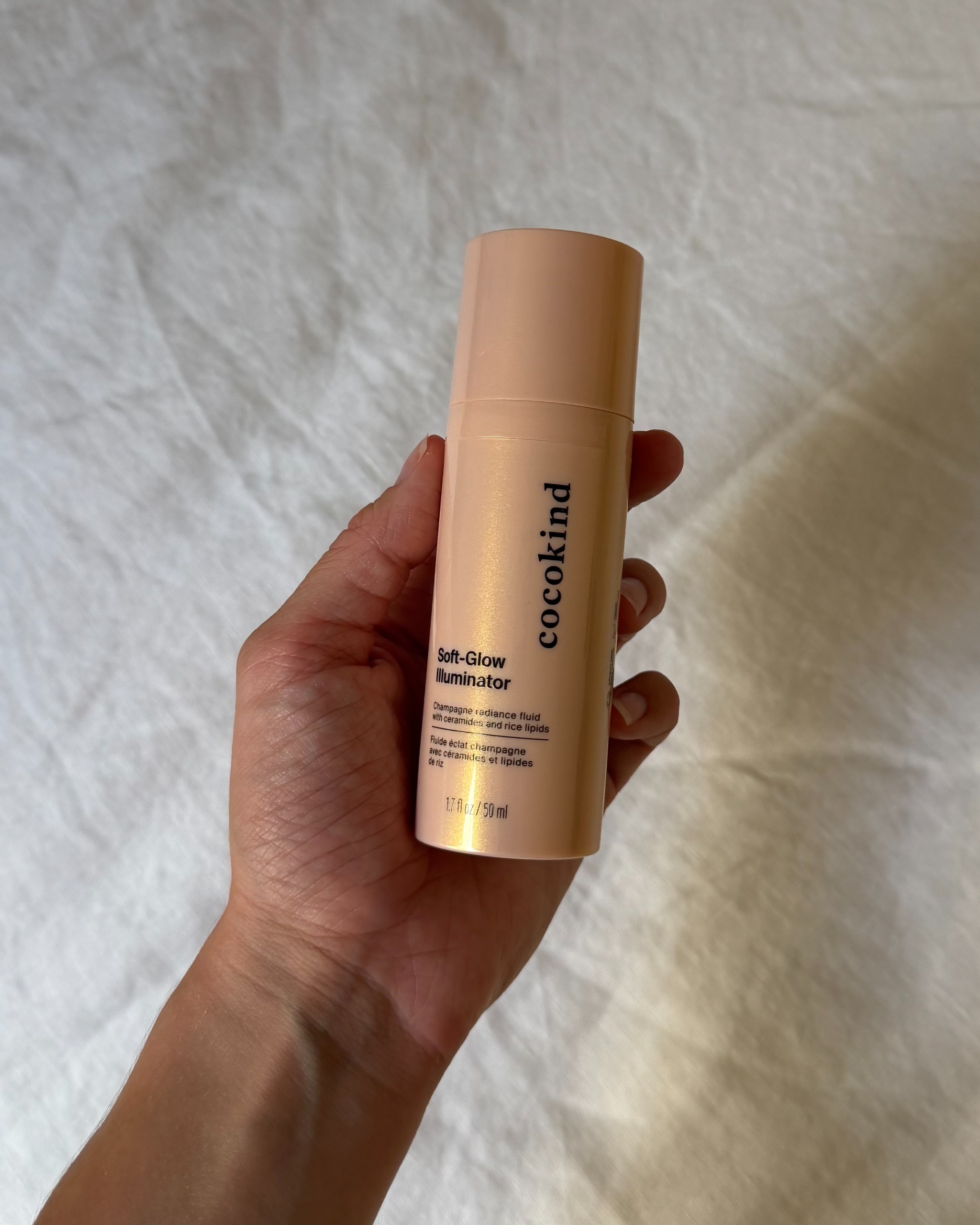 An image of WWW associate beauty editor Alyssa Brascia holding the new Cocokind Soft-Glow Illuminator.
