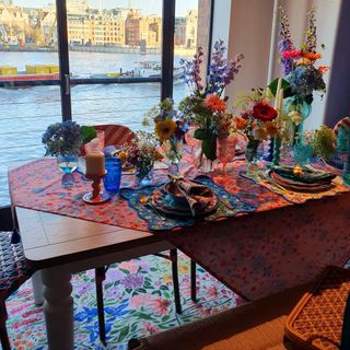 A dining room set up with the dining table decorated with table linen and tableware from the Dunelm x Sophie Robinson collection